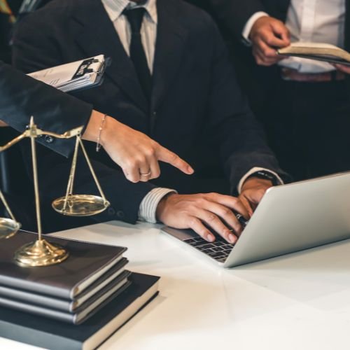 3 advogados apontando para o computador e discutindo uma estratégia jurídica